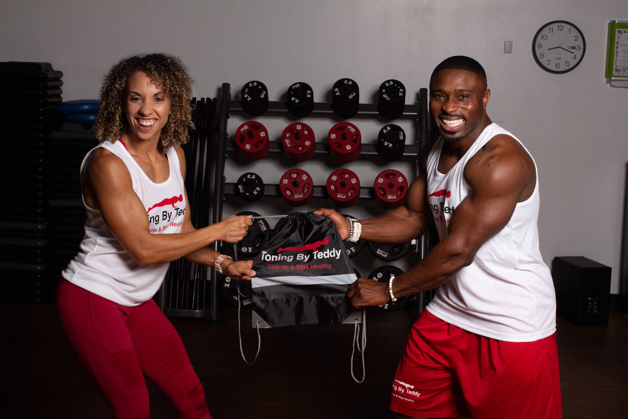 Teddy and a partner joyfully tugging a drawstring gym bag