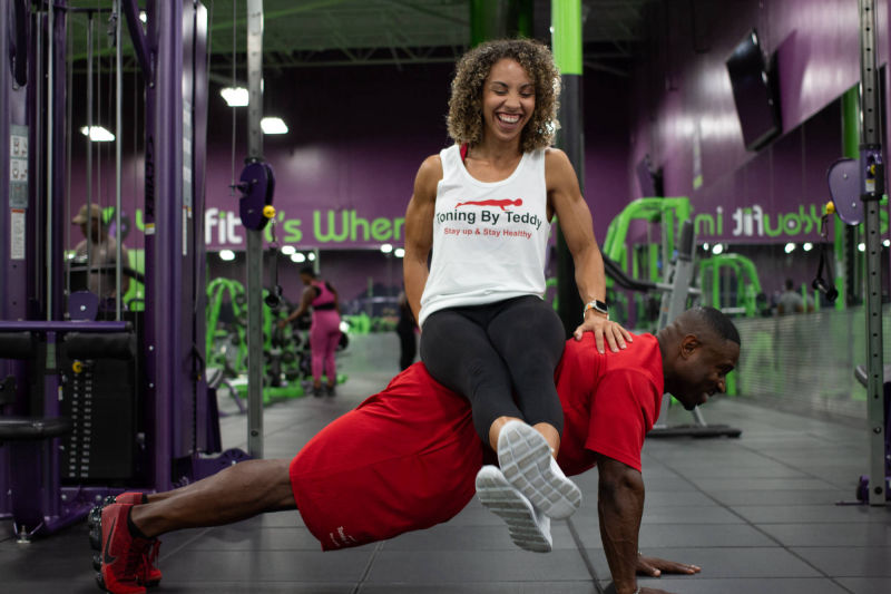 Teddy and a client smiling together in the gym